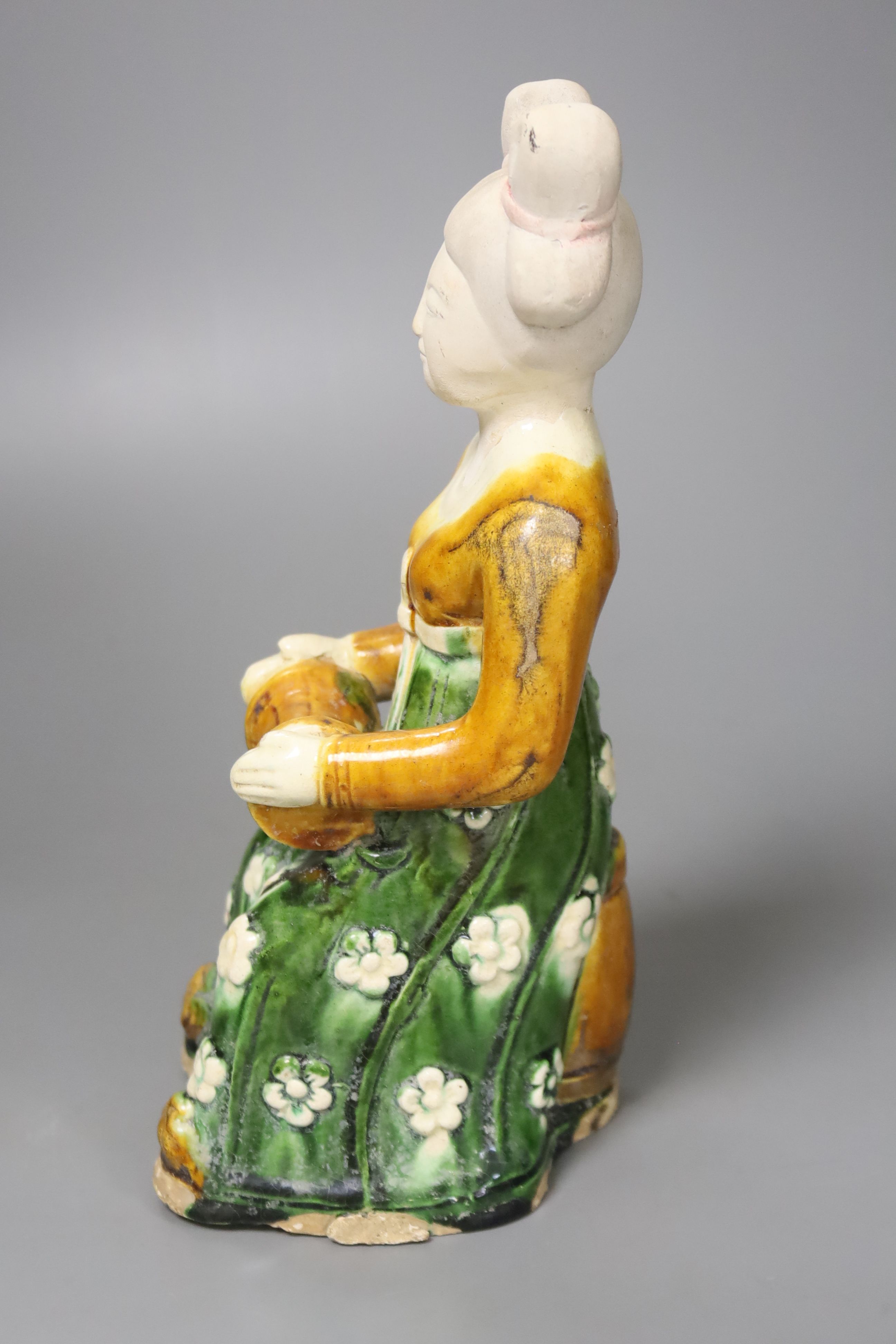 A large Chinese pottery figure of an aristocratic lady, wearing a floral skirt and seated, Tang dynasty style, 23cm high